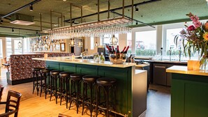 A modern bar area with stools, a bar counter, and a wine display. - Boutique Hotel Zaan (Zaandijk)