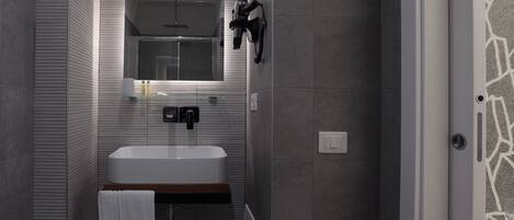 A modern bathroom with a large bathtub, a mirror above the sink, and a towel hanging on the wall.