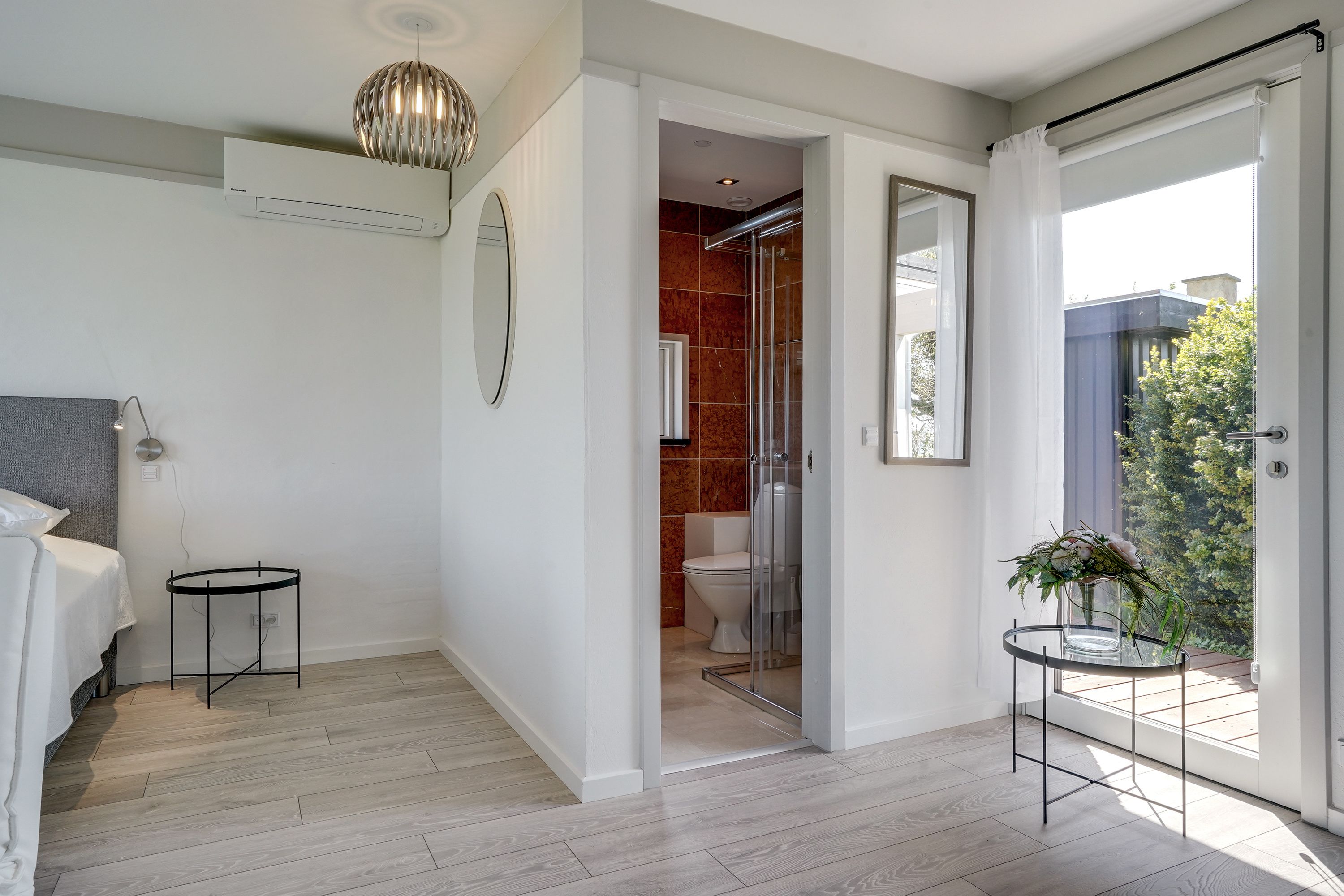Et moderne badeværelse med bruseniche, toilet og vask.