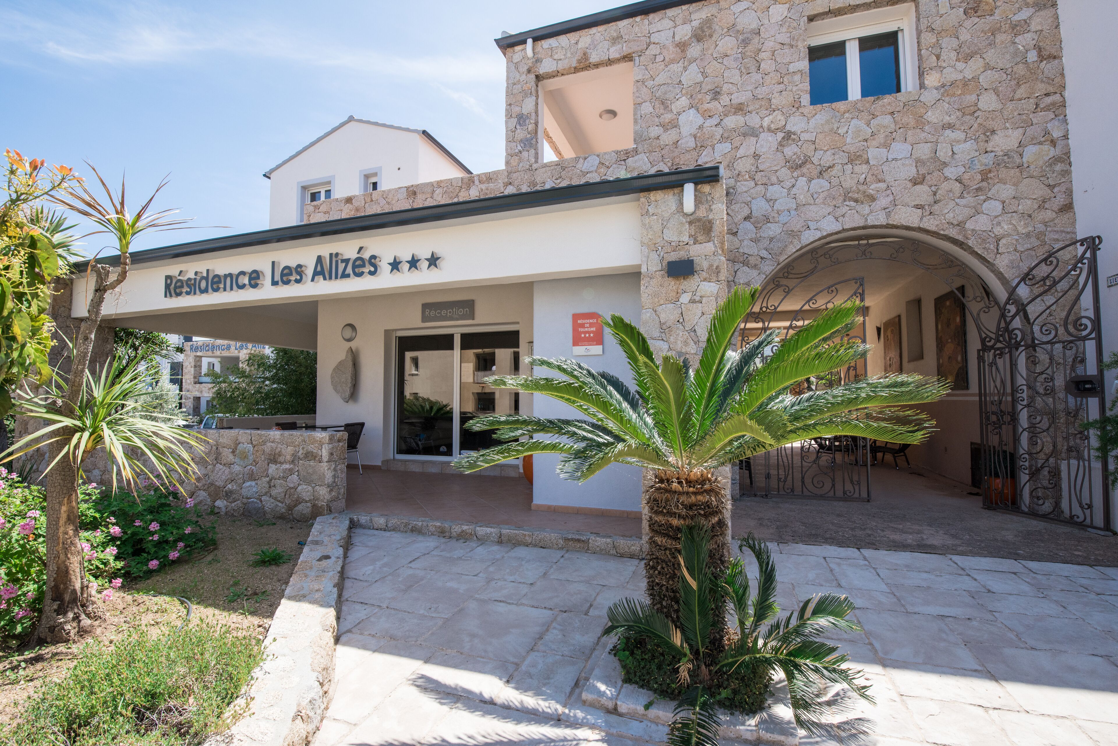 Un edificio con facciata in pietra, area reception e ingresso carrabile.