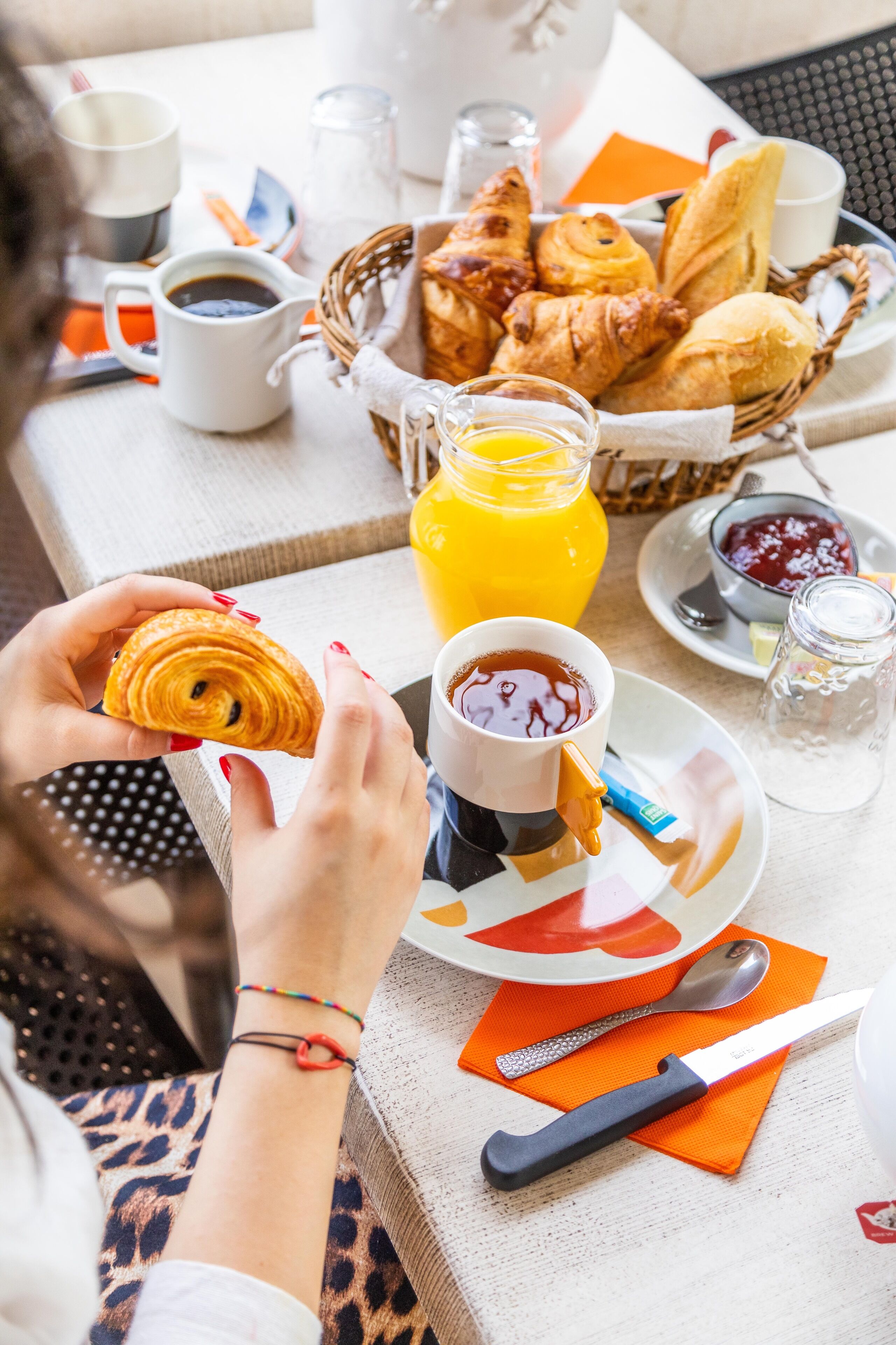 Een ontbijtje met croissants, koffie en sinaasappelsap op een tafel.