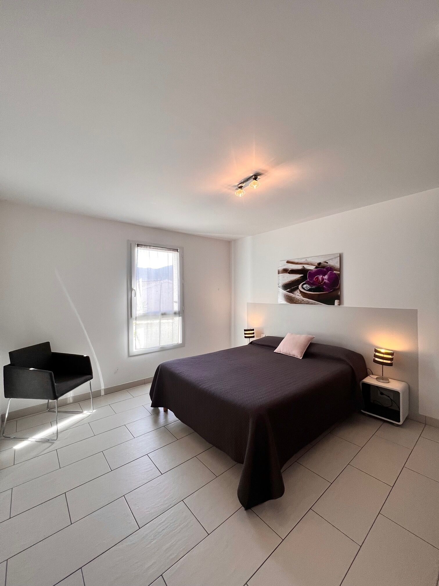 Une chambre à coucher moderne avec un grand lit, un bureau et une fenêtre.