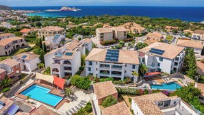 A coastal residential area with multiple buildings, a swimming pool, and a view of the sea. - Les Alizés Résidence & Spa  (Monticello)