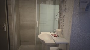 A modern bathroom with a glass-enclosed shower, a white sink, and a towel rack. - Hôtel Restaurant Glaizette (L'Argentiere-la-Bessee)