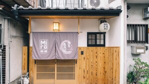A traditional Japanese entrance with a wooden gate, a lantern, and a sign with Japanese characters. - Miro Shijo Saiin Tei (Kyoto)