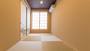 A room with tatami mats, a sliding door with a view of mountains, and an air conditioning unit on the wall. - Miro Shijo Saiin Tei (Kyoto)