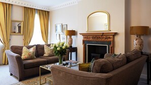 A living room with a fireplace, two sofas, a coffee table, and a mirror. - 9 Hertford Street Mayfair (London)