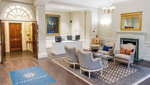 A spacious living room with a fireplace, comfortable seating, and a large painting on the wall. - 9 Hertford Street Mayfair (London)
