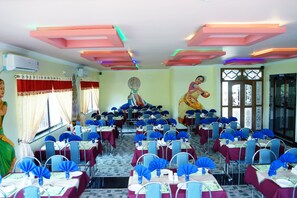 A banquet hall with rows of tables, each with blue tablecloths and matching chairs. - Tranquil Greens (Udumbanchola)
