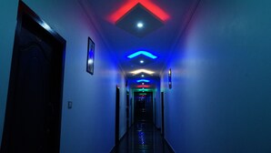 Un couloir doté d’un plafond au design moderne, agrémenté de formes géométriques et d’un éclairage à LED.
