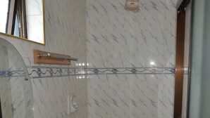 Une salle de bain avec un lavabo, un miroir et une douche.