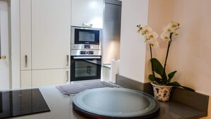 Una cucina moderna con elettrodomestici integrati, un'isola centrale e un'orchidea in vaso.
