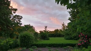 A garden with a variety of plants and a well-maintained lawn. - La Ferme Aux Charmes (Solre-le-Château)