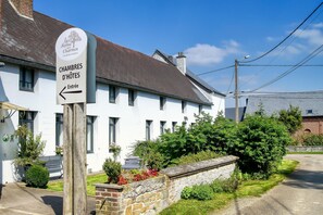 A white building with a sign indicating 'Chambres D'Hotes' and an entrance arrow. - La Ferme Aux Charmes (Solre-le-Château)
