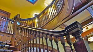A grand staircase with ornate balusters and a skylight above. - Hilltop Inn (Newport)