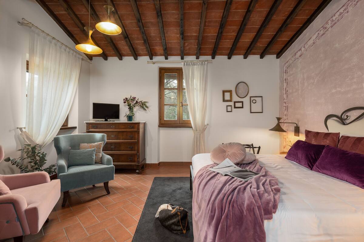 Une chambre à coucher comprenant un lit, un bureau, une chaise, une commode et un téléviseur.