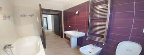 A bathroom with a bathtub, a pedestal sink, and a bidet. - Villa Aurelio (Squillace)