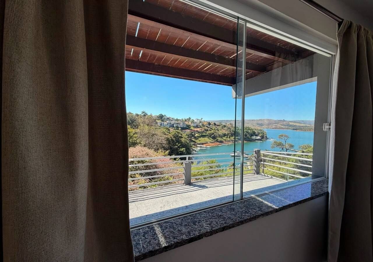 Una habitación con un amplio ventanal que ofrece vistas panorámicas de un lago y el paisaje circundante.