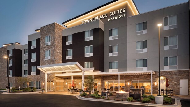 Un hotel Towneplace Suites Marriott con un área de estar al aire libre techada y una entrada bien iluminada.
