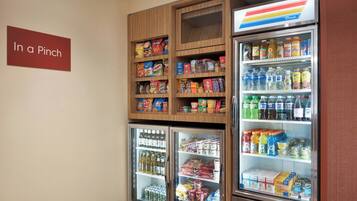 Zona de máquinas expendedoras con aperitivos, bebidas y productos refrigerados.
