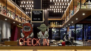 A hotel lobby with a check-in counter, a staircase, and a bar area. - Moxy Chattanooga Downtown (Chattanooga)