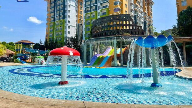A water park with slides and fountains, surrounded by multi-story residential buildings.