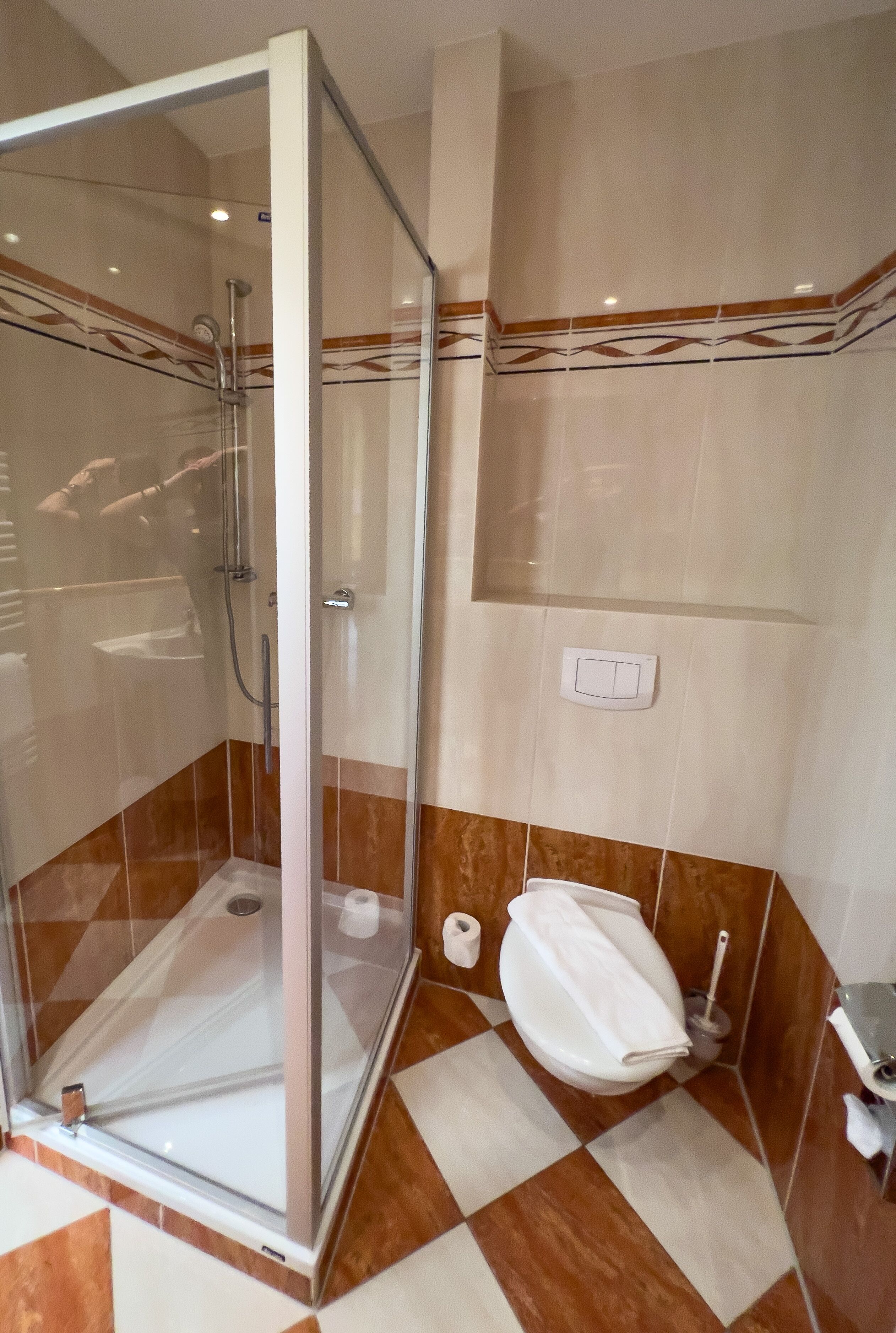 A bathroom with a glass-enclosed shower, a toilet, and a sink.