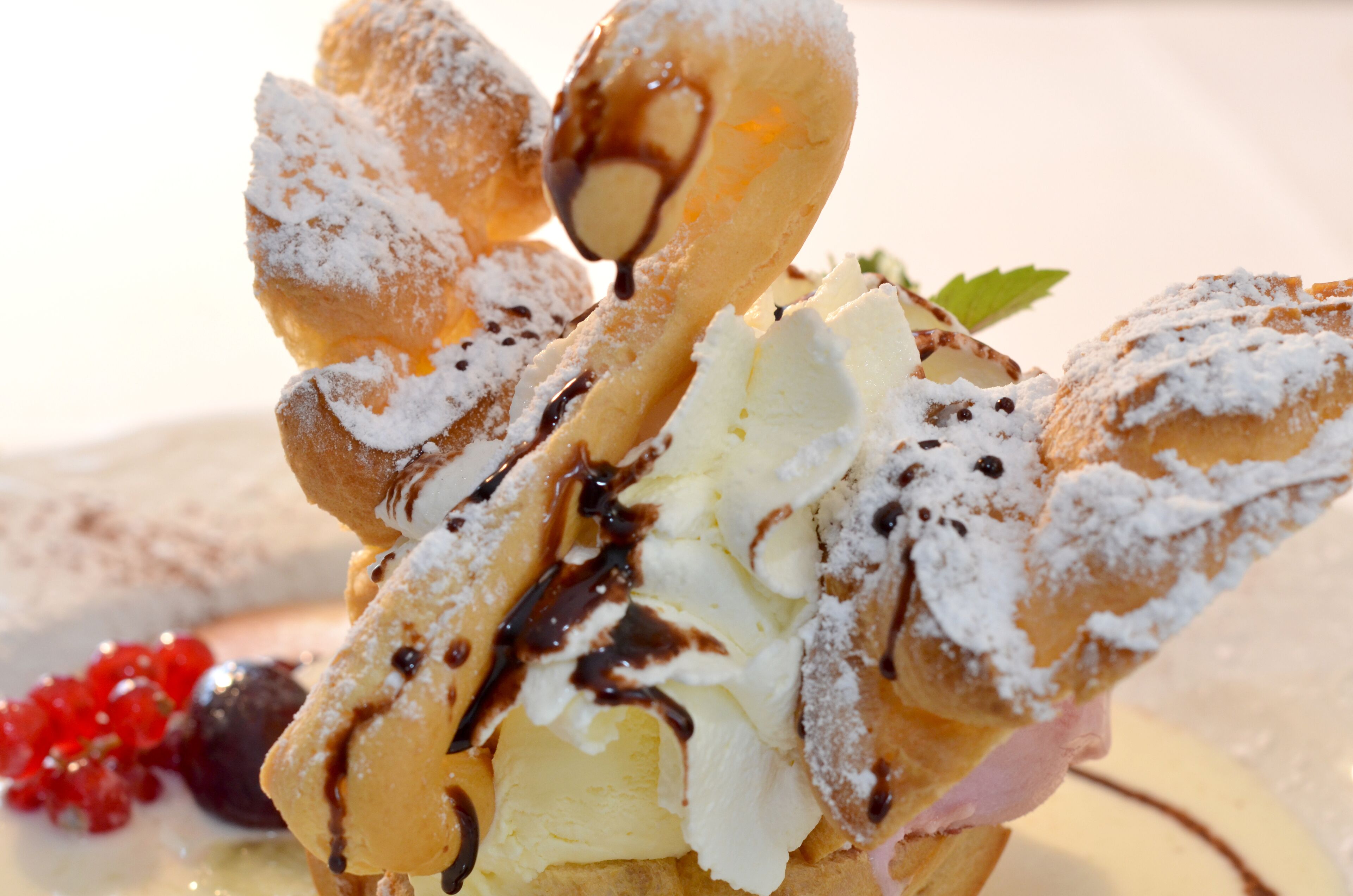 Un dessert composé de crème fouettée, de sauce au chocolat et de sucre glace.