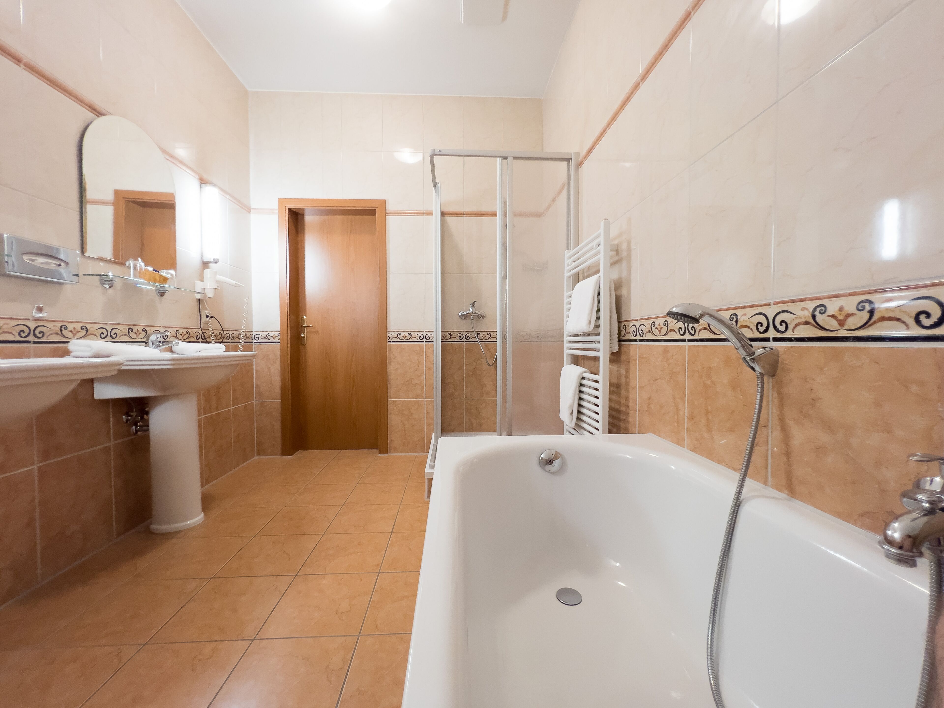 Un baño con bañera, lavabo y ducha.
