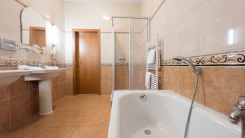 Un baño con bañera, lavabo y ducha.