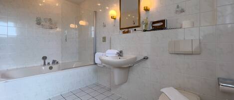 A modern bathroom with a bathtub, sink, and toilet.