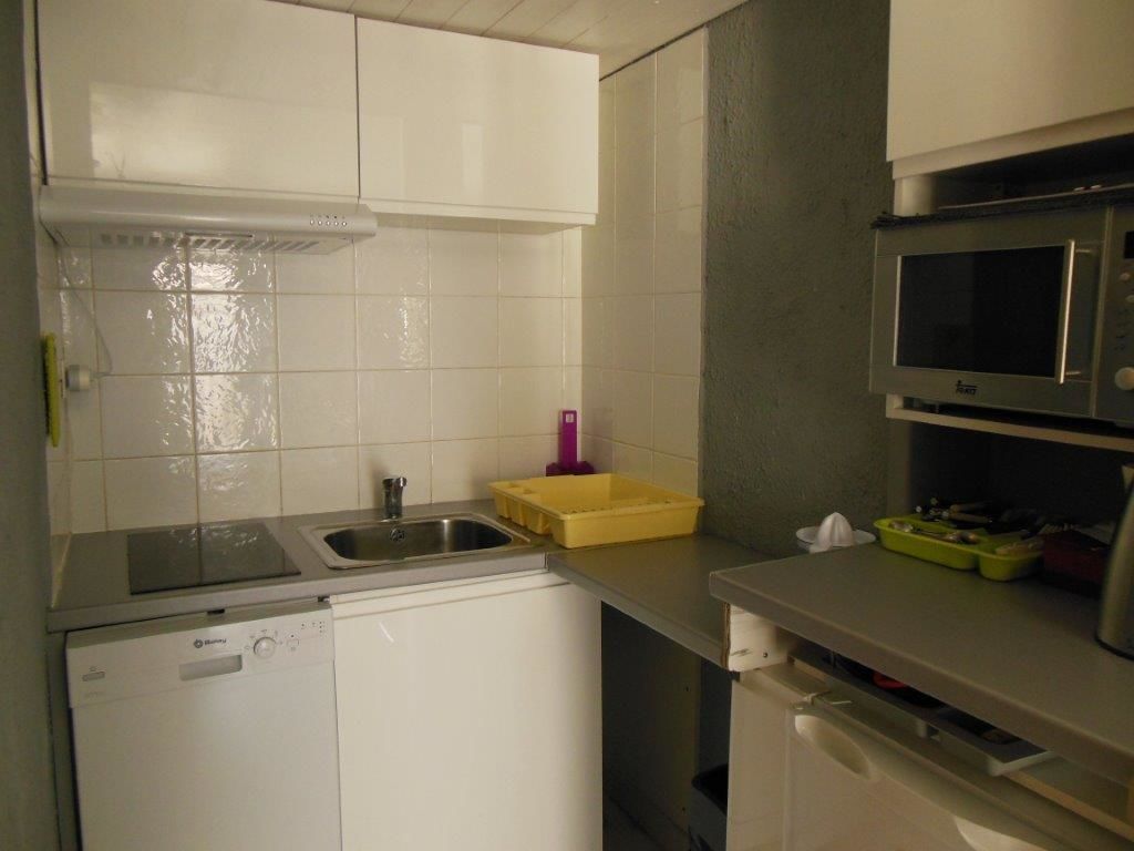 A compact kitchen with a dishwasher, a sink, a microwave, and a small countertop.