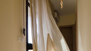A hallway with a sheer curtain, a ceiling light, and a door at the end. - White Rose Villa (Kassandra)