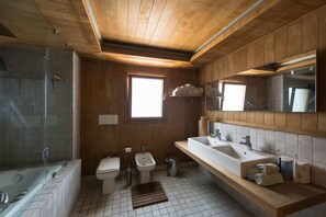 A modern bathroom with wooden paneling, a large window, a walk-in shower, and a vanity with dual sinks. - Cosmopolitan Maison (Thessaloniki)