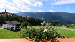 A house with a garden in front, a road, and mountains in the background. - Hotel Tirolerhof (Terento)