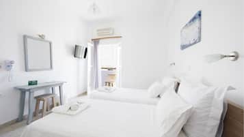 A hotel room with two beds, a desk, a mirror, a TV, and a painting on the wall.