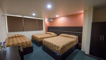 A hotel room with two beds, a desk, and a wardrobe.