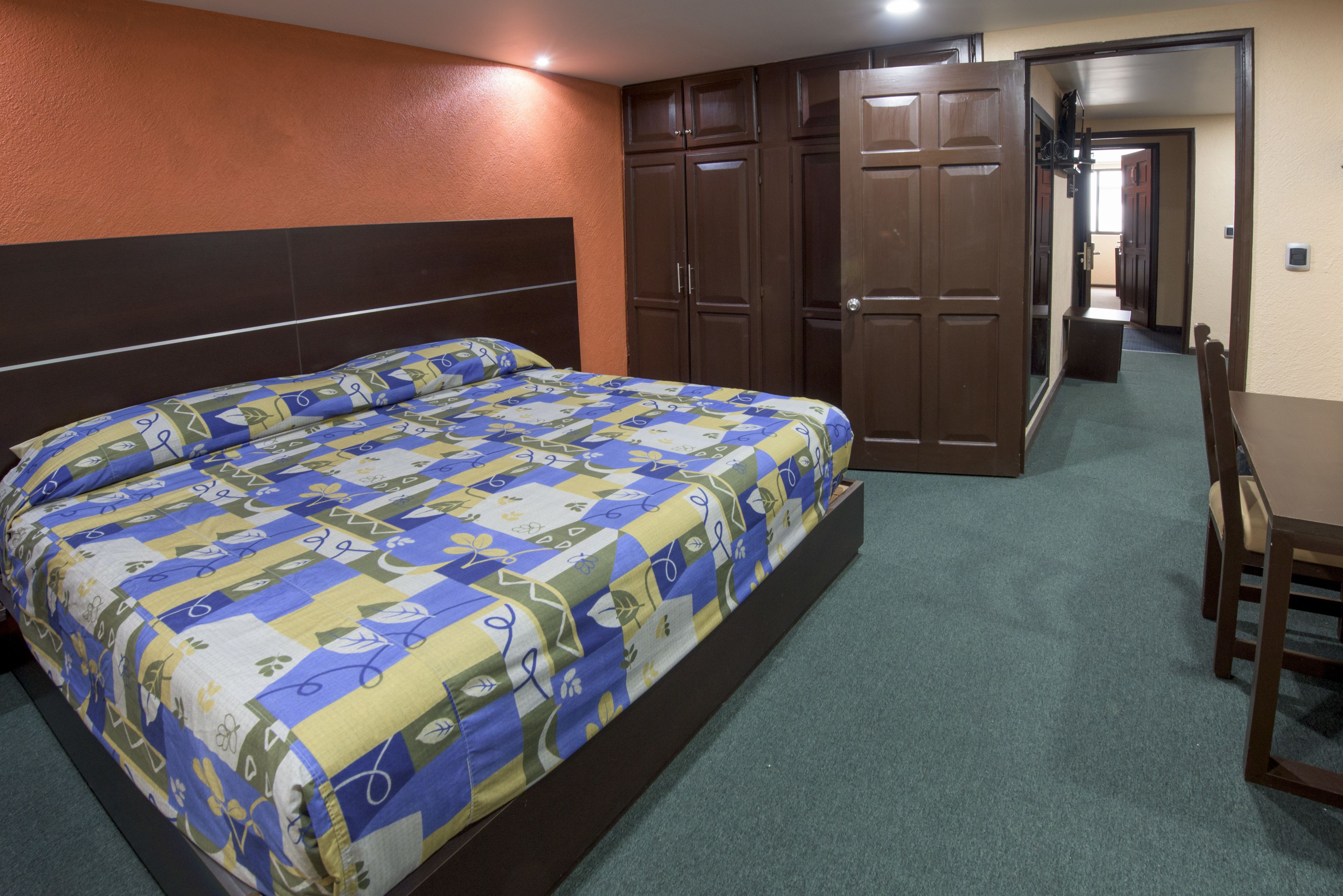 Un dormitorio con una cama grande, un armario y un espejo.