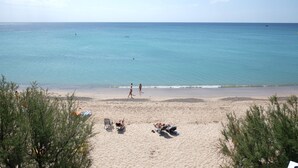 A beach with clear skies, calm water, and people sunbathing. - Playa Montroig Camping Resort (Mont-roig del Camp)