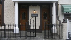 The exterior of The Anchorage, a building with a sign above the entrance and a smaller sign below it. - The Anchorage (Amlwch)
