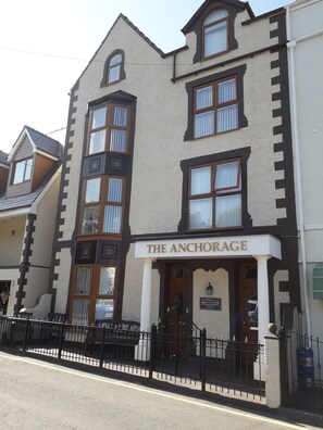 Un edificio con un letrero que dice "The Anchorage". Presenta un estilo arquitectónico tradicional, con múltiples ventanas y una entrada destacada.