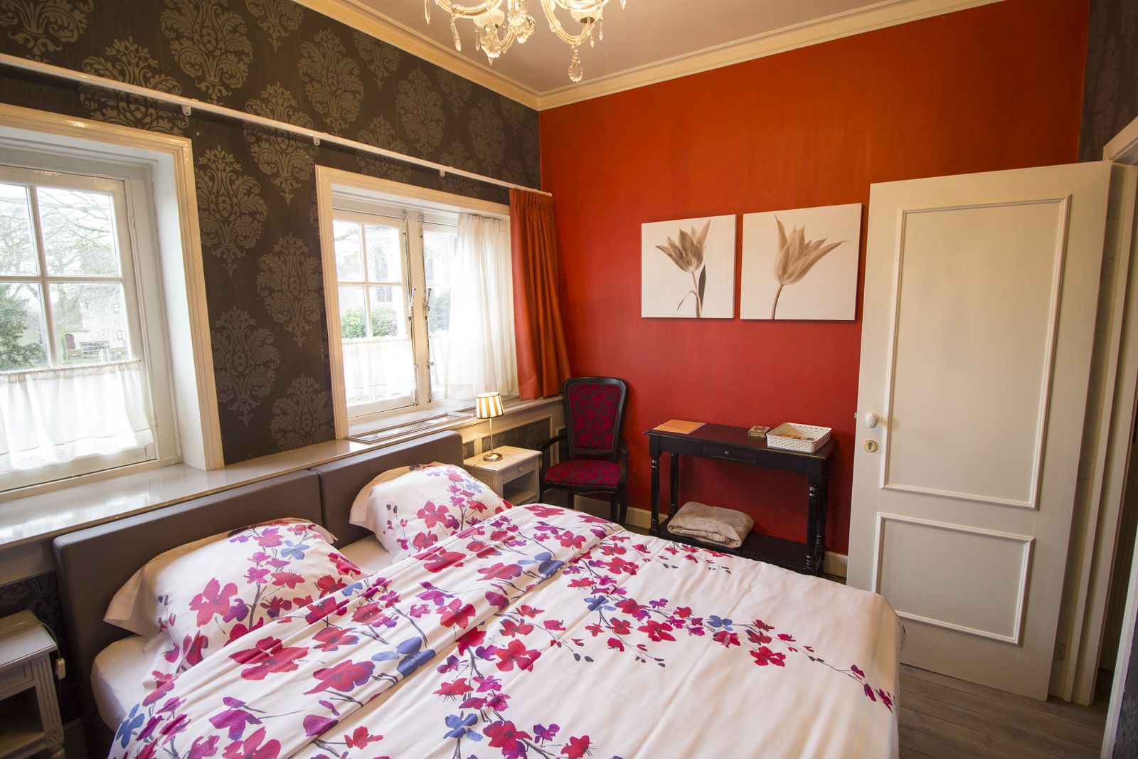 Een slaapkamer met een bed, een bureau, een stoel en een kledingkast.