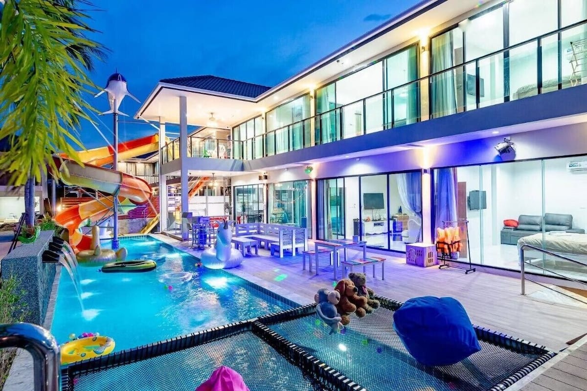 A modern hotel with a pool area, including a slide and seating.