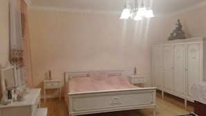A bedroom with a bed, nightstands, a dresser, and a chandelier. - Sweet Home (Kazbegi)