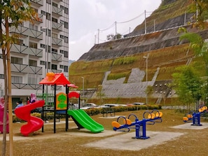 Explore the outdoor playground with a slide, climbing structure, and seesaw.