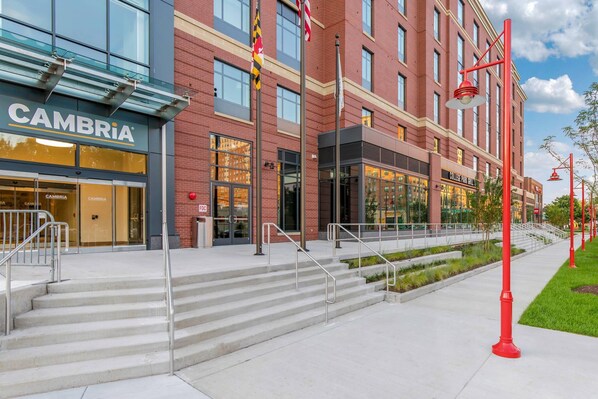 A multi-story building with a storefront labeled 'CAMBRIA' and a visible entrance with steps leading up to the door.