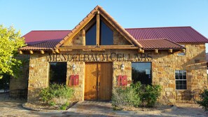 A stone building with a red roof and a sign that reads "MENDELBACH CELLARS". - The Lofts at Mendelbaum Cellars (Fredericksburg)
