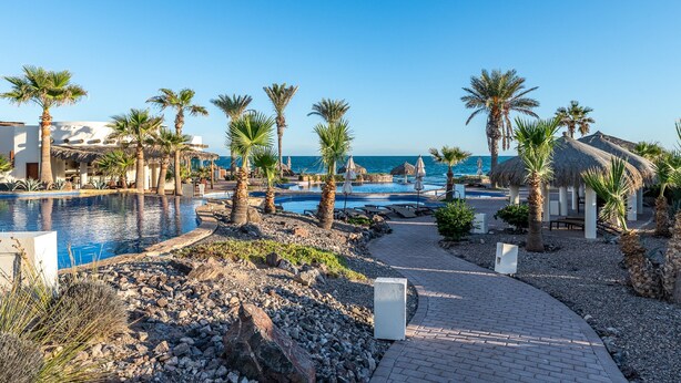 A resort with multiple swimming pools, palm trees, and a beach view. - Luna Blanca Villa 07 by Kivoya (Puerto Peñasco)