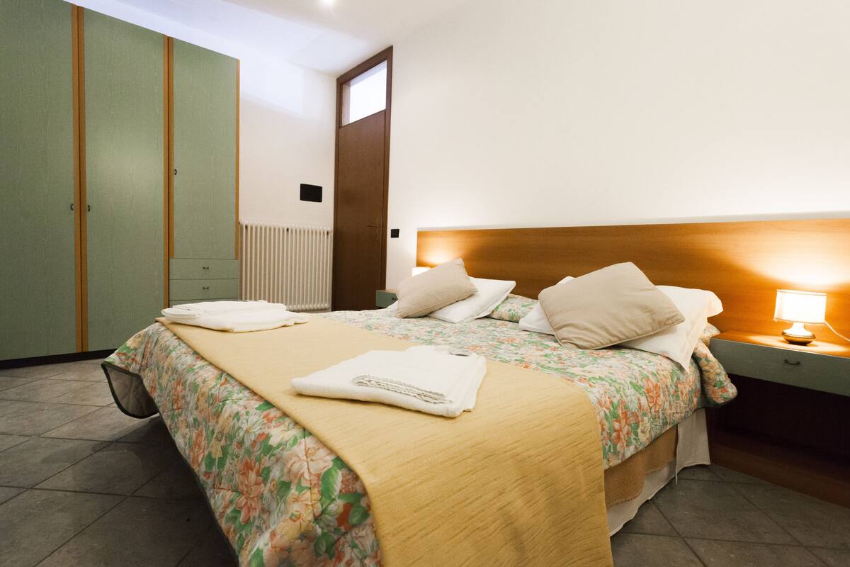 Une chambre d’hôtel équipée d’un lit, d’une table de chevet, d’une lampe et d’une armoire.