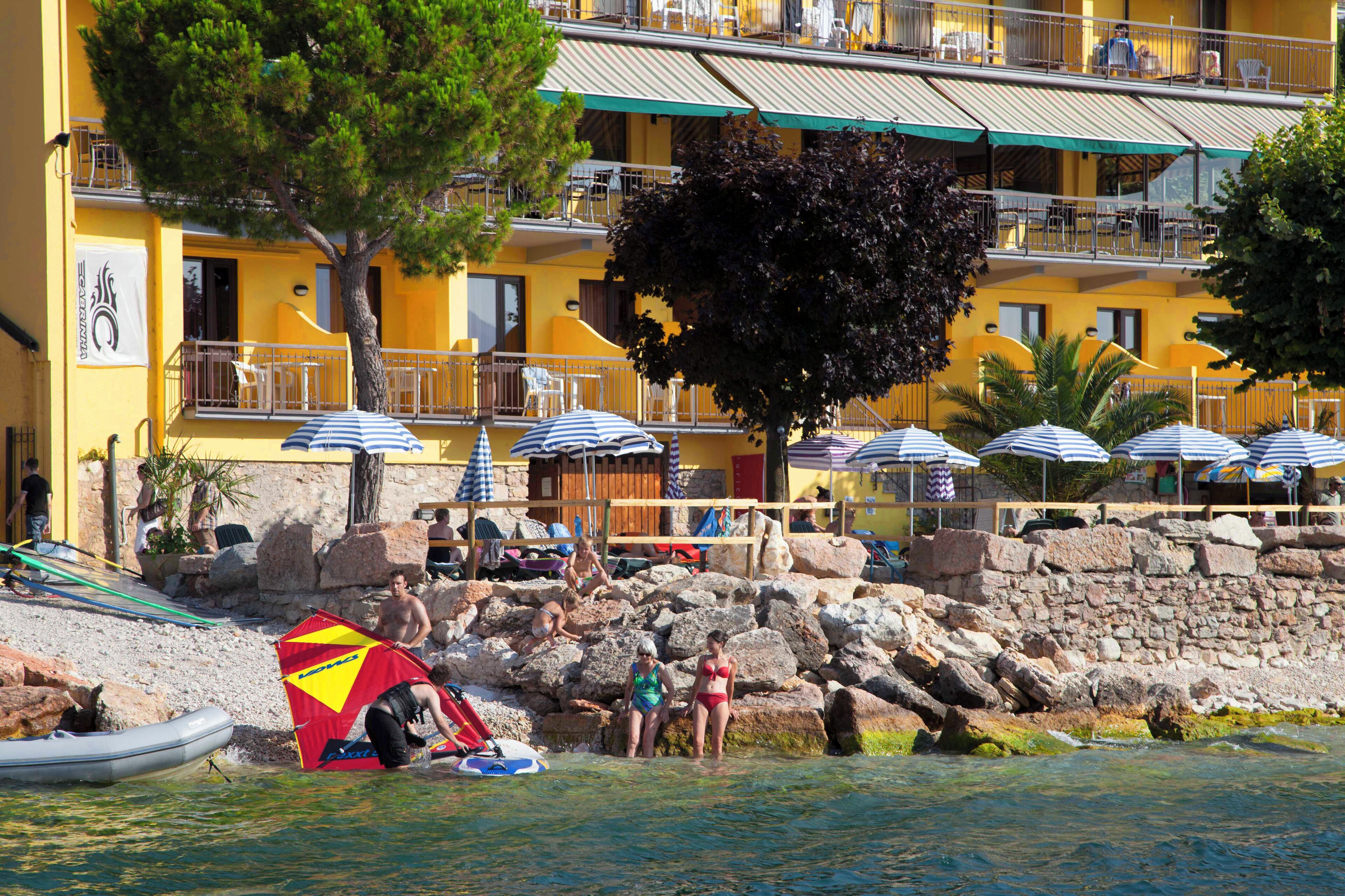 Un hôtel situé sur la côte, doté d’une terrasse, d’une piscine et d’un rivage rocheux.